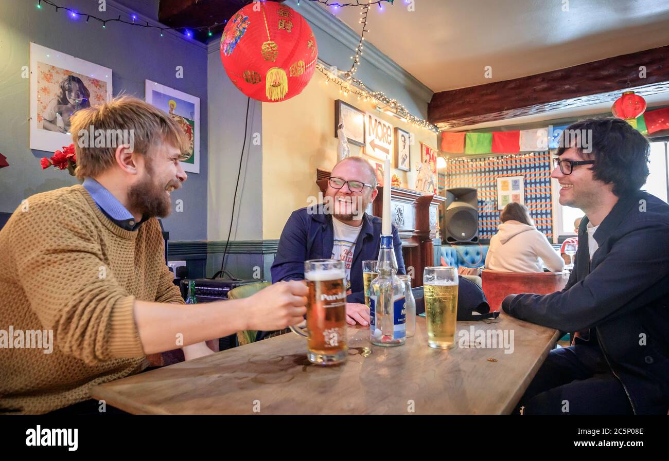 Los clientes disfrutan de una bebida en el pub Golden Lion en Todmorden, West Yorkshire, mientras se reabre tras la relajación de las restricciones de bloqueo de coronavirus en toda Inglaterra. Foto de stock