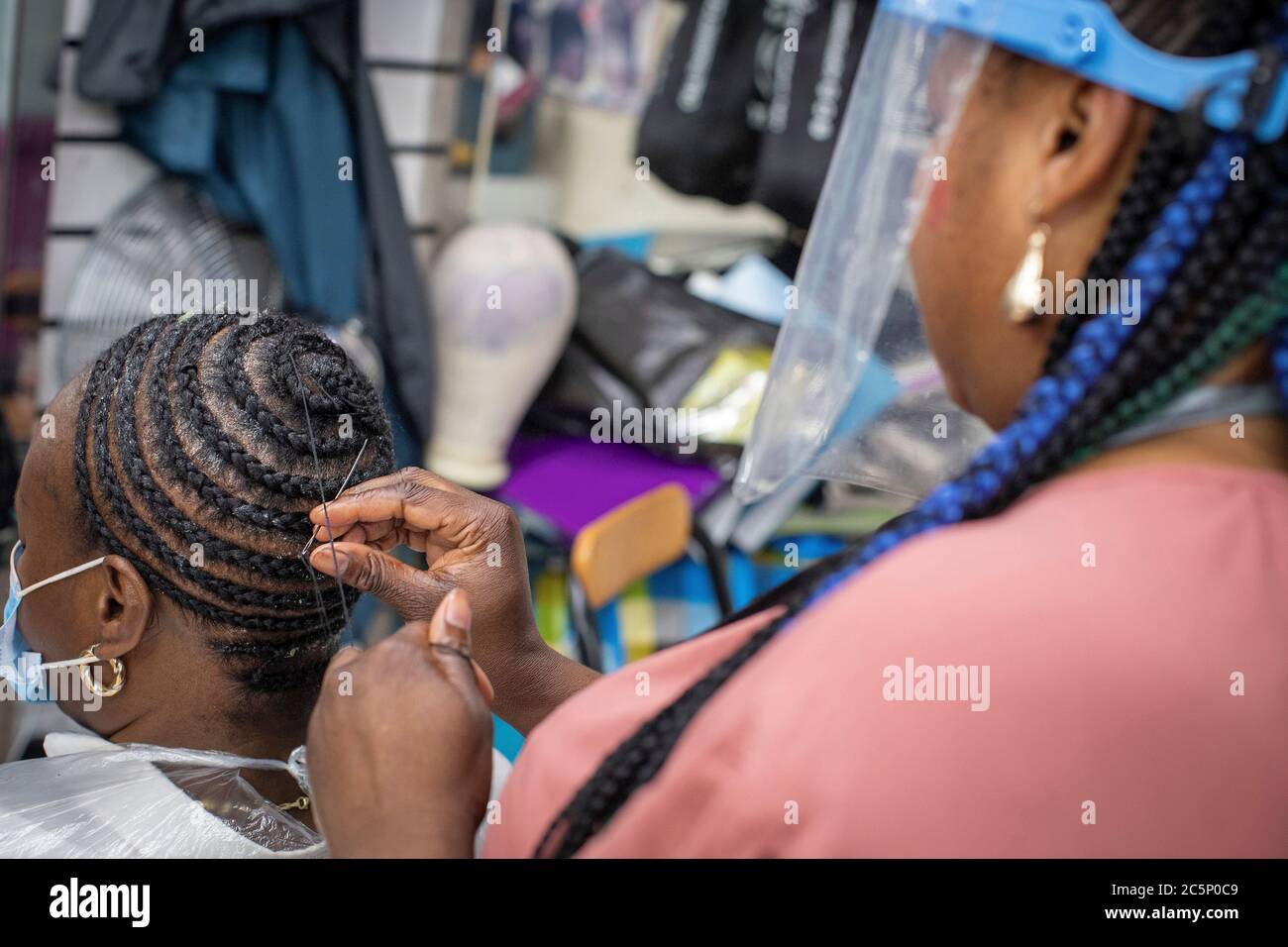 Peckham, Inglaterra. 4 de julio de 2020. Una mujer que tenía su pelo trenzado y trenzado en el salón de peluquería estilo en Peckham en los salones de día reabrir habiendo sido cerrado durante más de tres meses en el Reino Unido debido a la pandemia de coronavirus. (Foto de Sam Mellish / Alamy Live News) Foto de stock