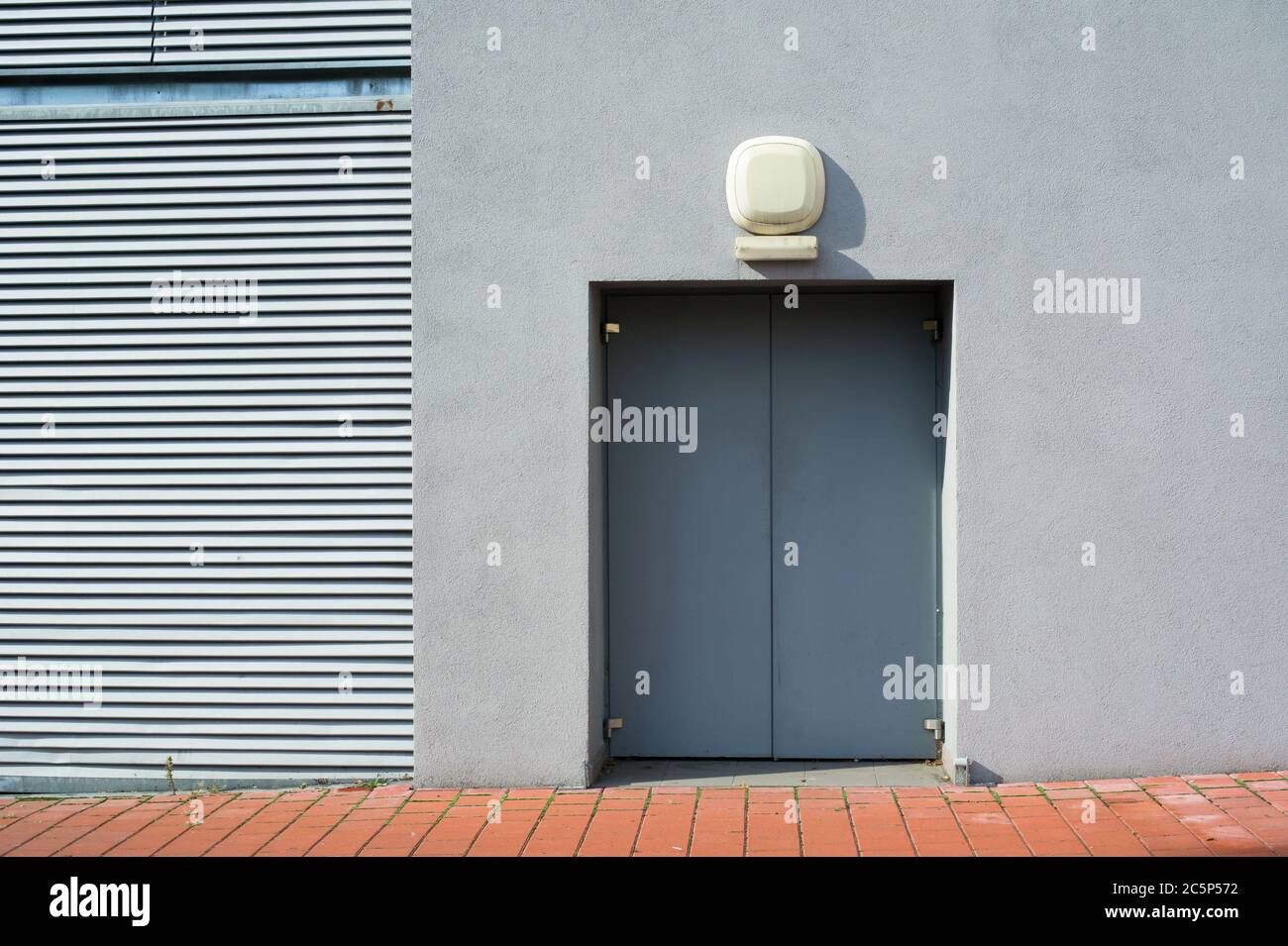 Detalle de un edificio gris sencillo y minimalista con puerta - geometría de líneas angulares y espacio de copia Foto de stock
