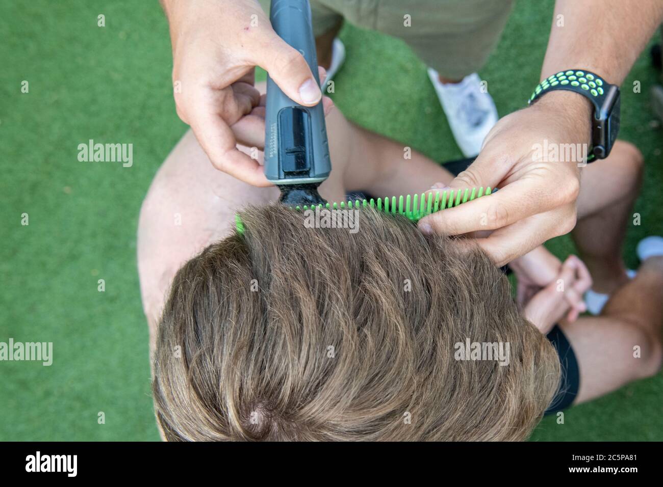 Un corte de pelo cerrado para un niño adolescente en el jardín Foto de stock
