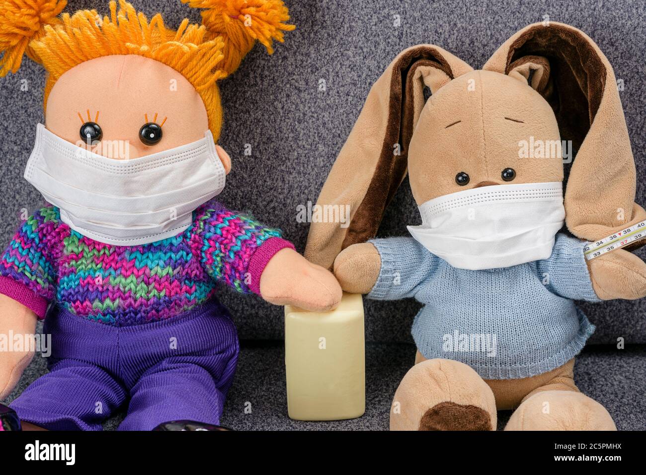 La máscara protectora protege contra el coronvirus y la epidemia de gripe. Concepto de lavarse las manos con jabón después de comunicarse entre sí. Juguetes blandos si Foto de stock