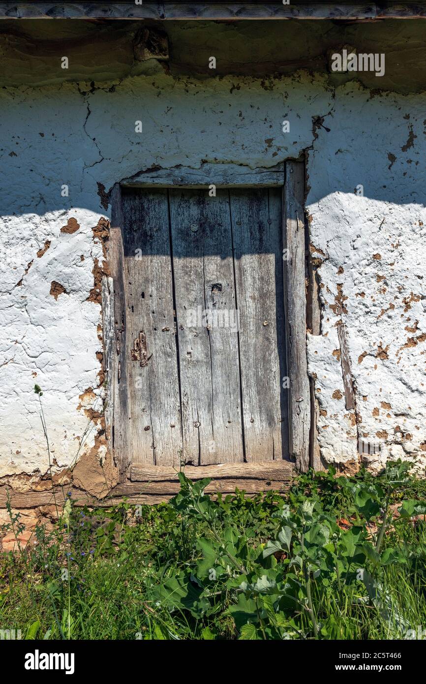 Una casa con exterior encalado y una puerta de madera, desagüe y vierteaguas  Fotografía de stock - Alamy