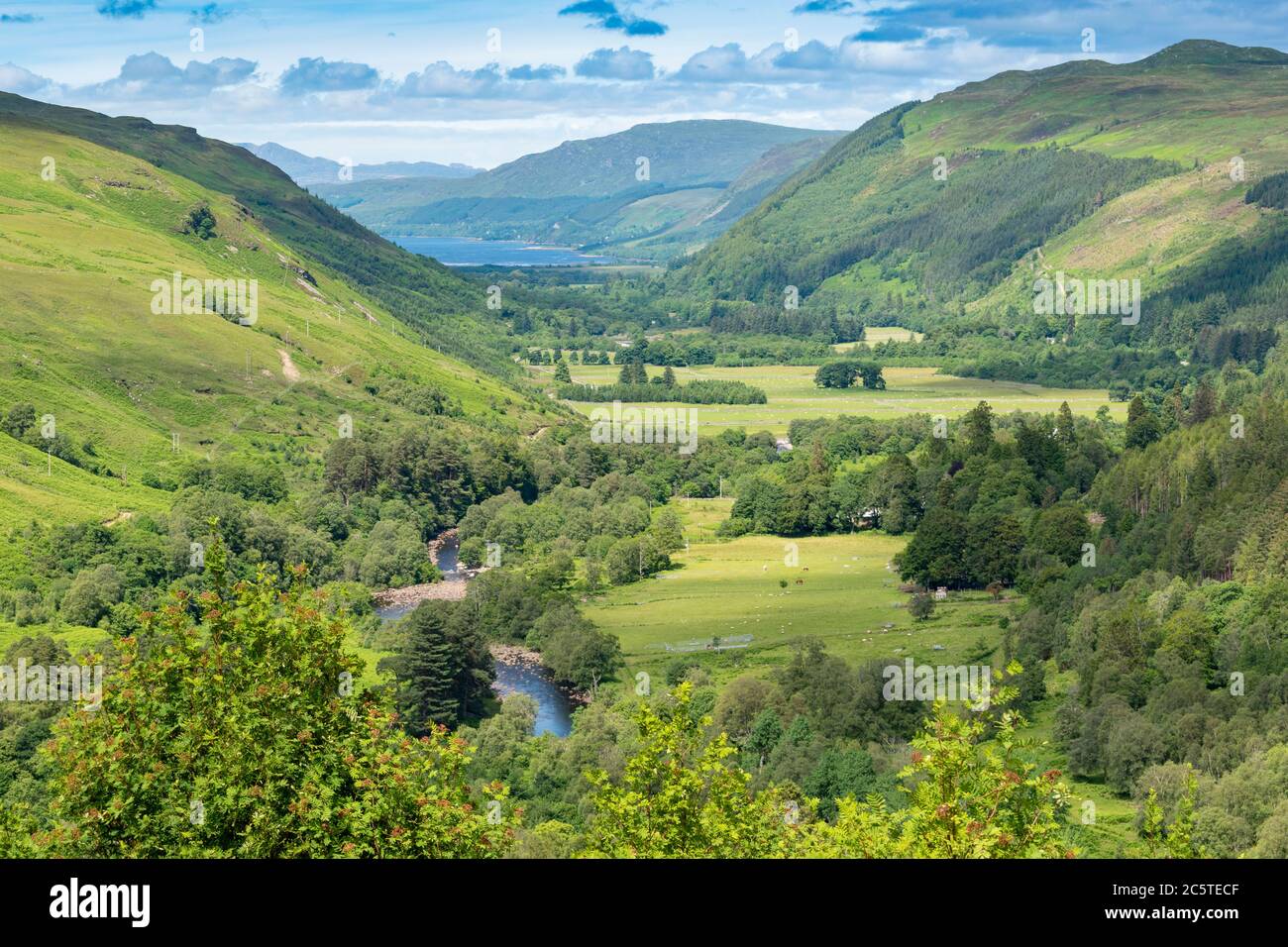 LAS TIERRAS ALTAS DEL DESFILADERO DE CORRIESHALLOCH ESCOCIA EN VERANO Y EL RÍO ABHAINN DOMA QUE FLUYE A TRAVÉS DE LA ESCOBA DEL DESFILADERO DEL LAGO EN LA DISTANCIA Foto de stock