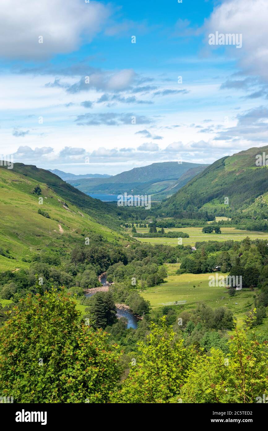 LAS TIERRAS ALTAS DEL DESFILADERO DE CORRIESHALLOCH ESCOCIA CERCA DE ULLAPOOL EN VERANO Y EL RÍO ABHAINN DROMA QUE FLUYE A TRAVÉS DE LA ESCOBA DEL DESFILADERO DEL LAGO EN LA DISTANCIA Foto de stock