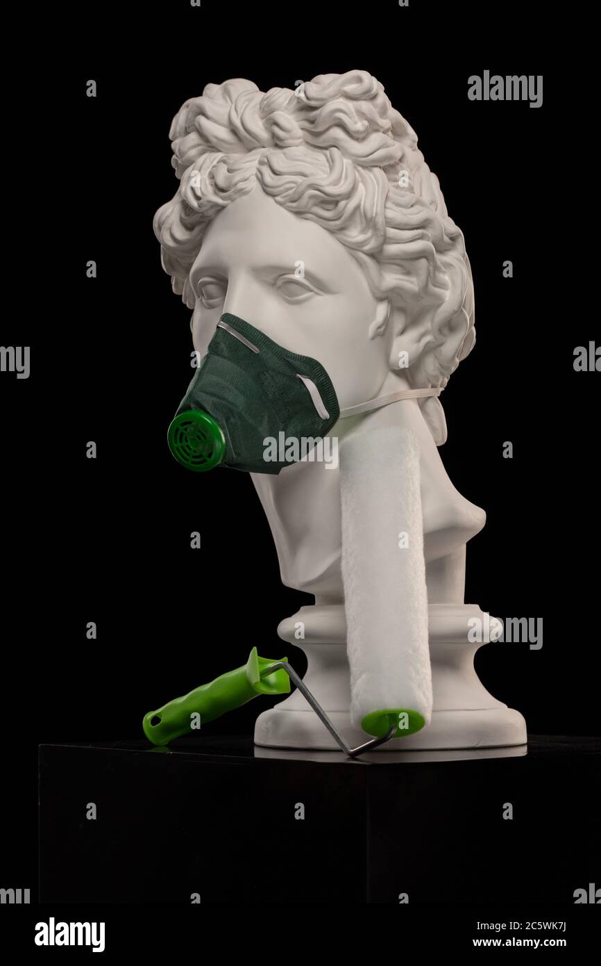 Estatua de yeso blanco de un busto de Apollo Belvedere en una máscara  mascarilla que cubre su cara y con un cepillo de rodillos para trabajos de  pintura Fotografía de stock -
