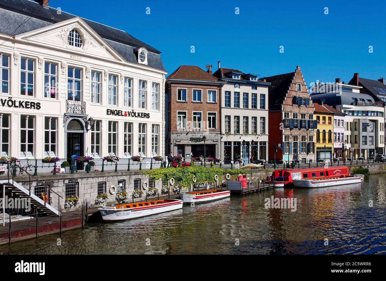canal escena, agua, un edificio de arquitectura flamenca, otros modernizados, pequeños barcos, tour, flores, Flandes, Europa, Gante; Bélgica Foto de stock