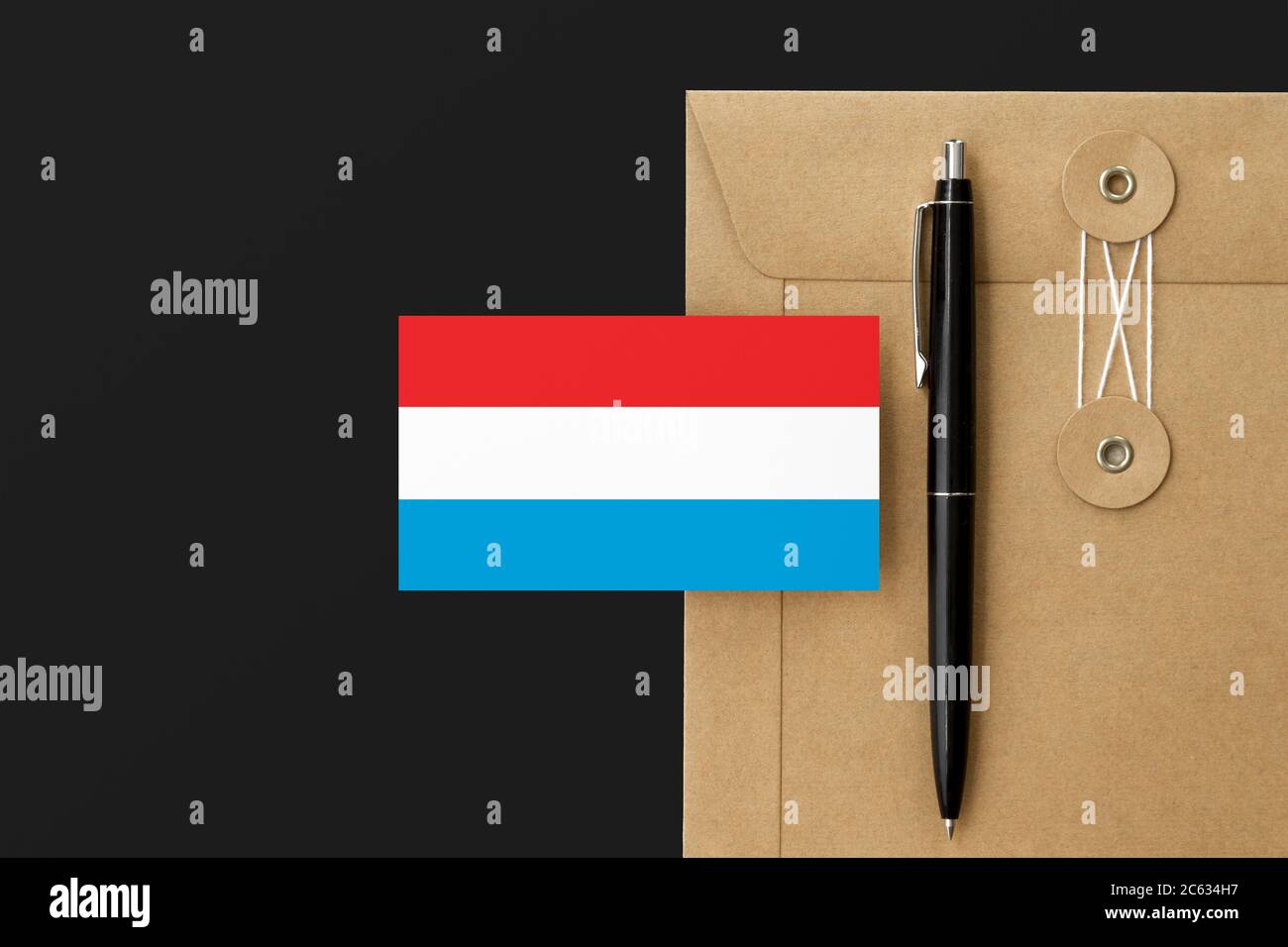Bandera de Luxemburgo sobre carta de sobre de artesanía y fondo negro