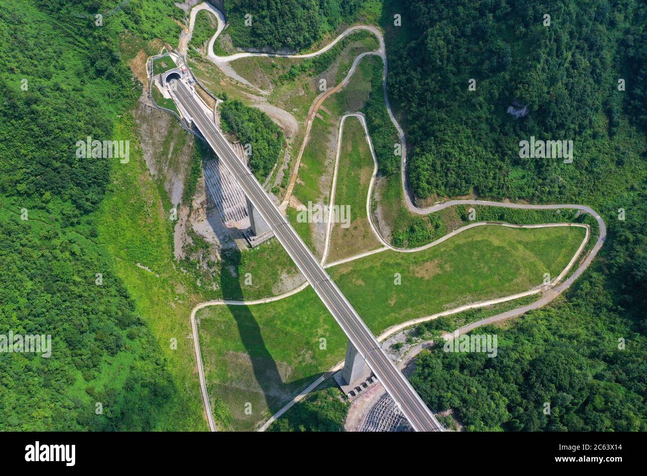 Pekín, China. 6 de julio de 2020. Foto aérea tomada el 6 de julio de 2020 muestra un puente ferroviario a lo largo del ferrocarril Anshun-Liupanshui en la provincia de Guizhou, al suroeste de China. El ferrocarril interurbano Anshun-Liupanshui, con una velocidad de 250 km por hora, está en preparación para su apertura. El ferrocarril acortará el tiempo de viaje entre Guiyang y Liupanshui de las actuales 3.5 horas a aproximadamente 1 hora, y la ciudad de Liupanshui estará completamente conectada con la red nacional de trenes de alta velocidad. Crédito: Liu Xu/Xinhua/Alamy Live News Foto de stock