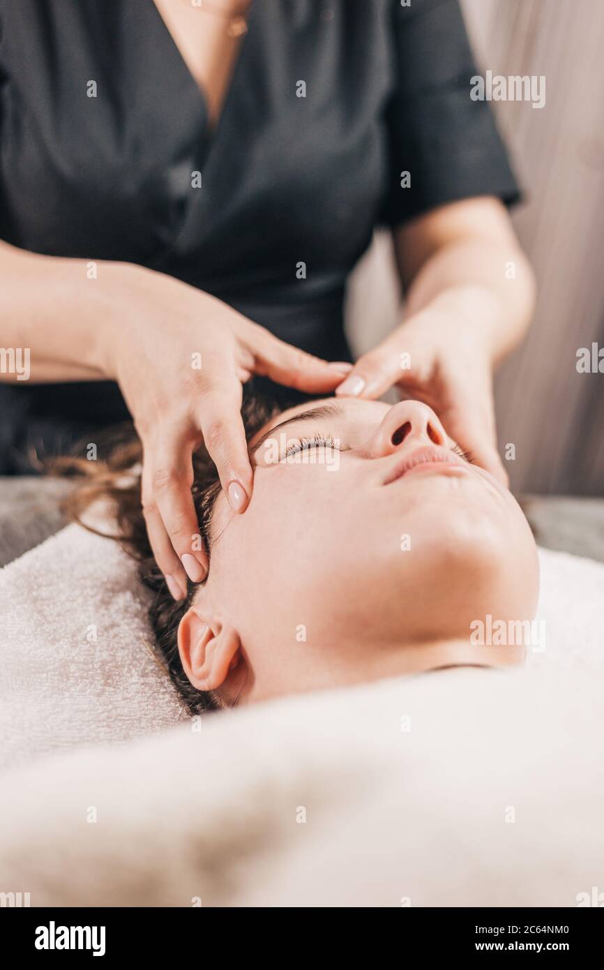 Masaje de la cara y cabeza de una niña en una sala de masajes -  tonificación de la piel Fotografía de stock - Alamy