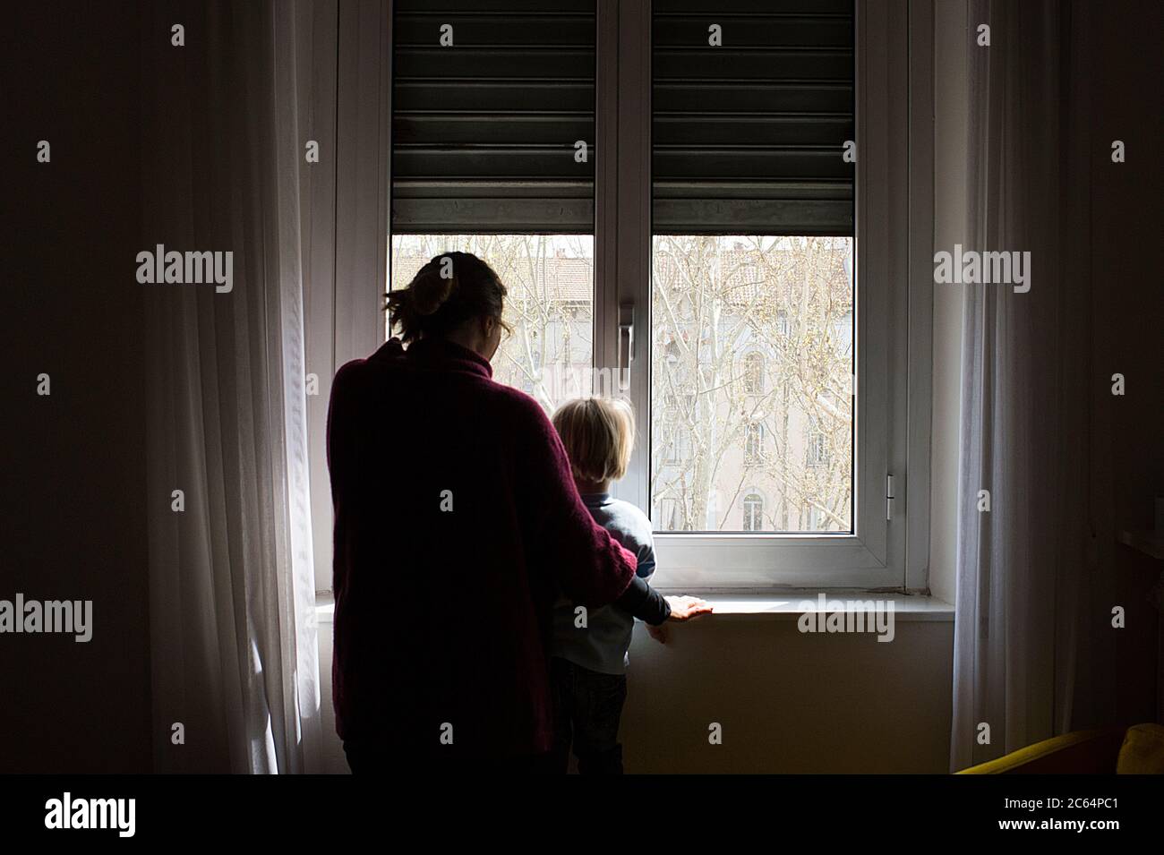 Niño y mamá en la ventana Foto de stock
