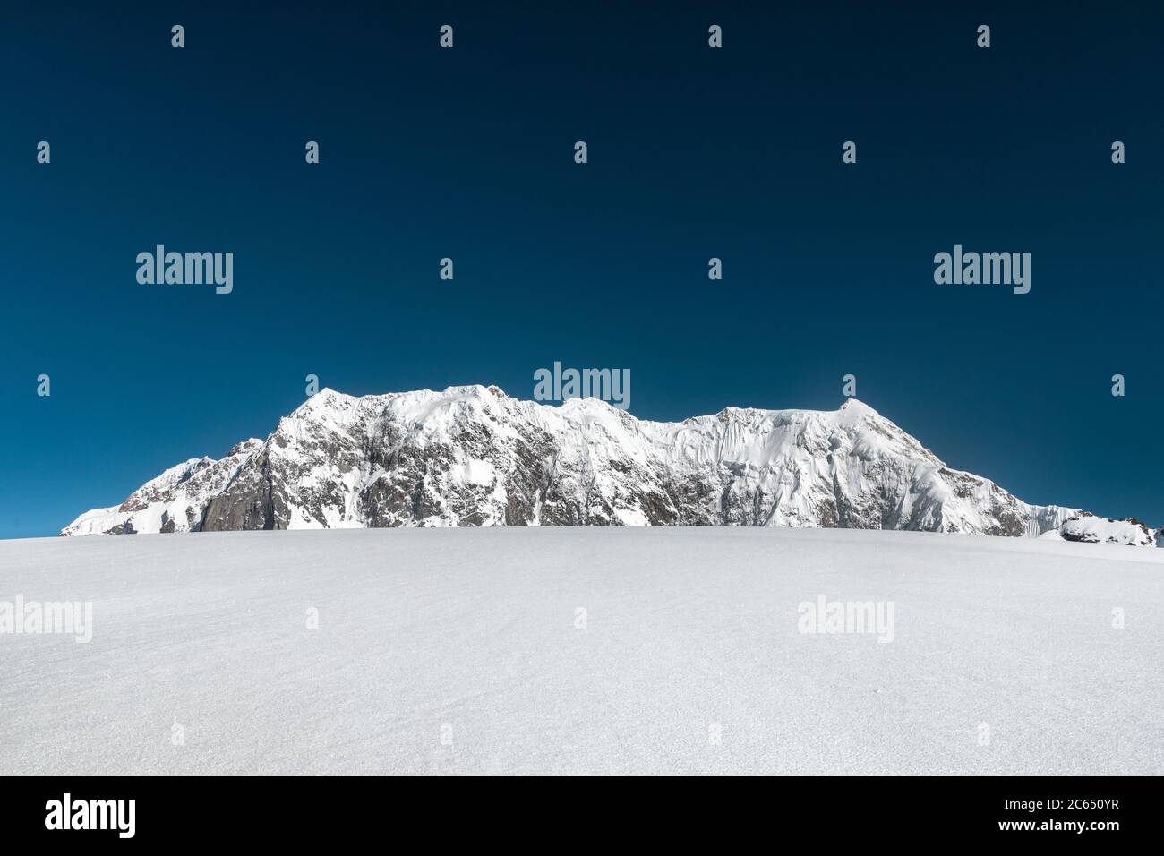 Senderismo en los campos de nieve de los Himalayas indios con la vista panorámica de alta altitud de las montañas más altas en el montañismo Foto de stock