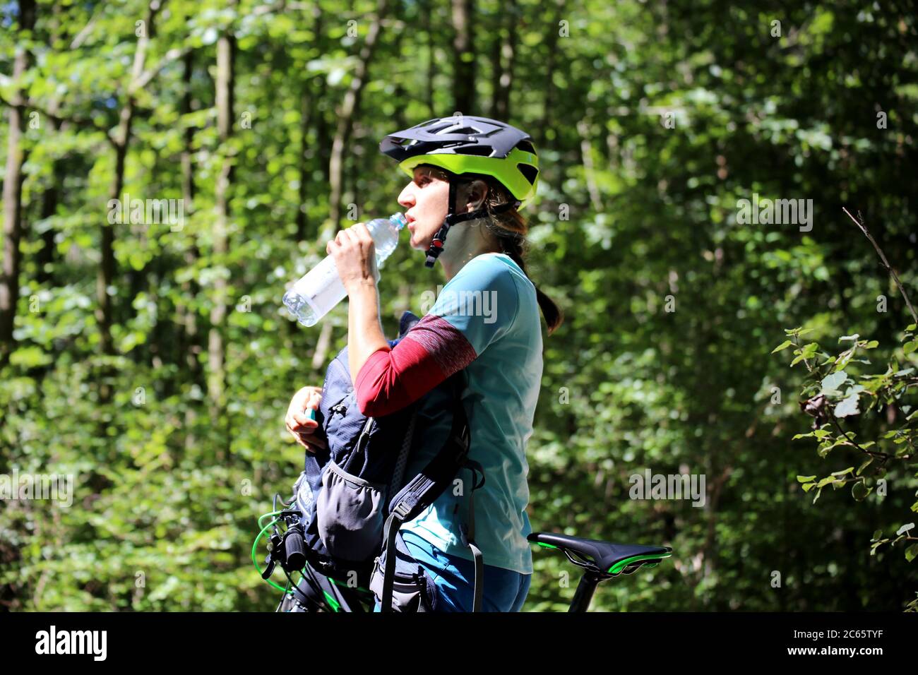 Symbolbild für ausreichend Trinken beim Sport: Mountainbikerin löscht ihren Durst (Modelo publicado) Foto de stock