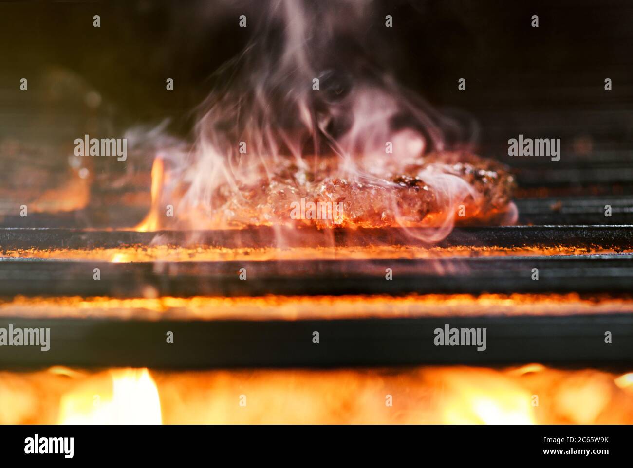 trozos de carne rodando sobre un fuego al aire libre con humo Fotografía de  stock - Alamy