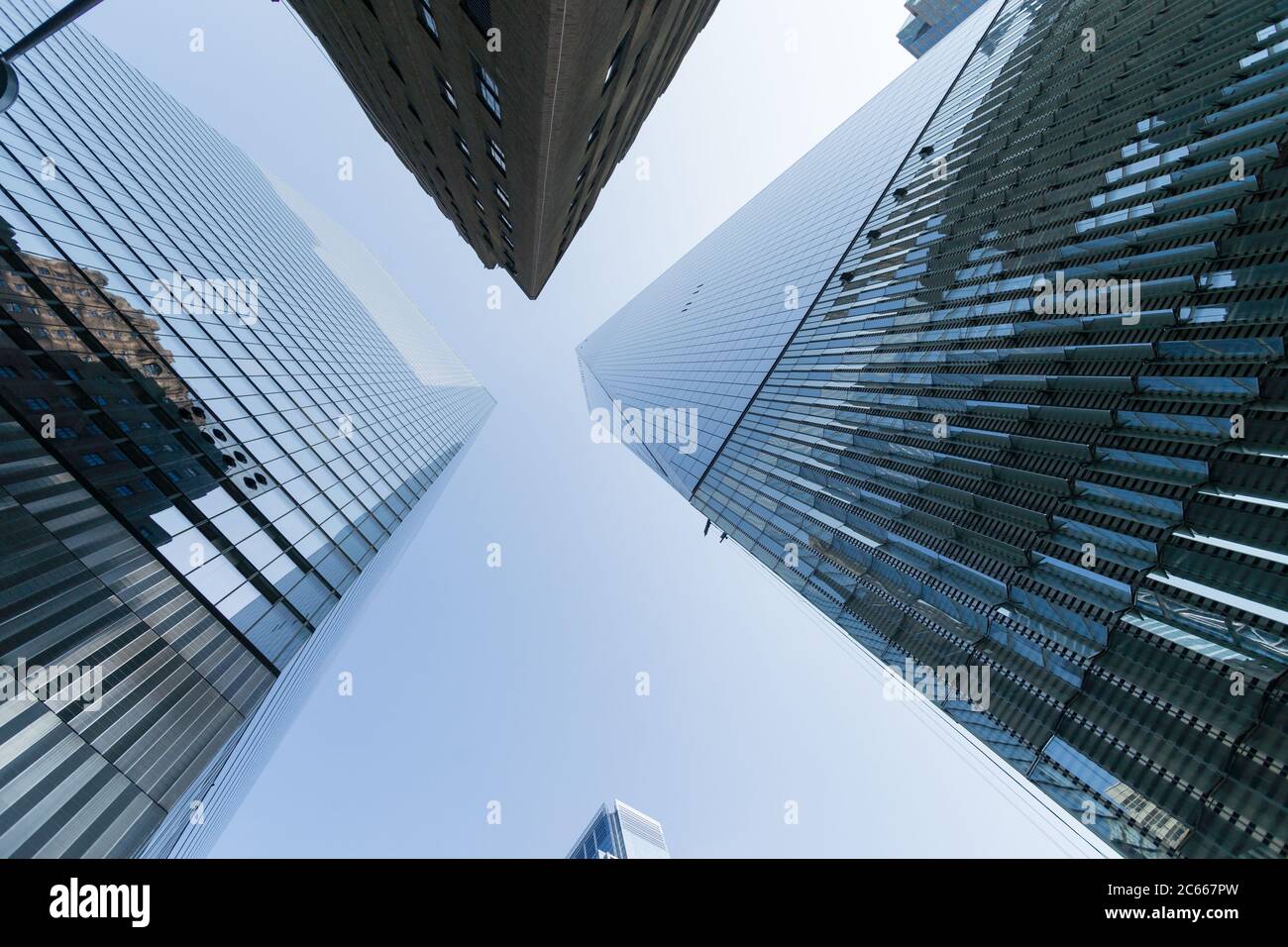 Imagen de gran angular en el rascacielos del bajo manhattan hasta el cielo con efecto espejo en el edificio. Perspectiva decreciente Foto de stock