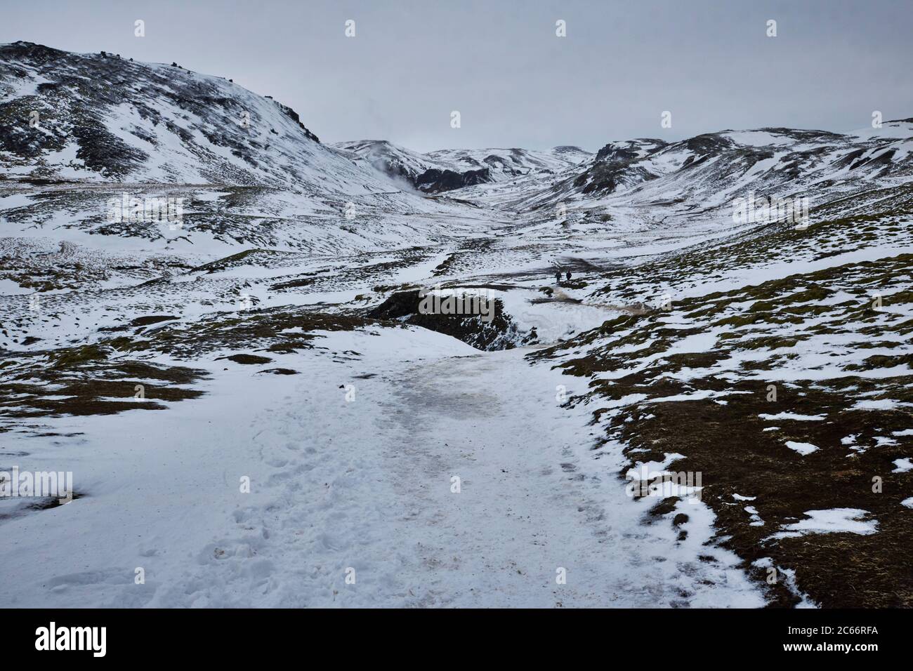 Islandia, el valle de Reykjadalur, Hveragerdi, montañas nevadas y fuentes geotérmicas Foto de stock