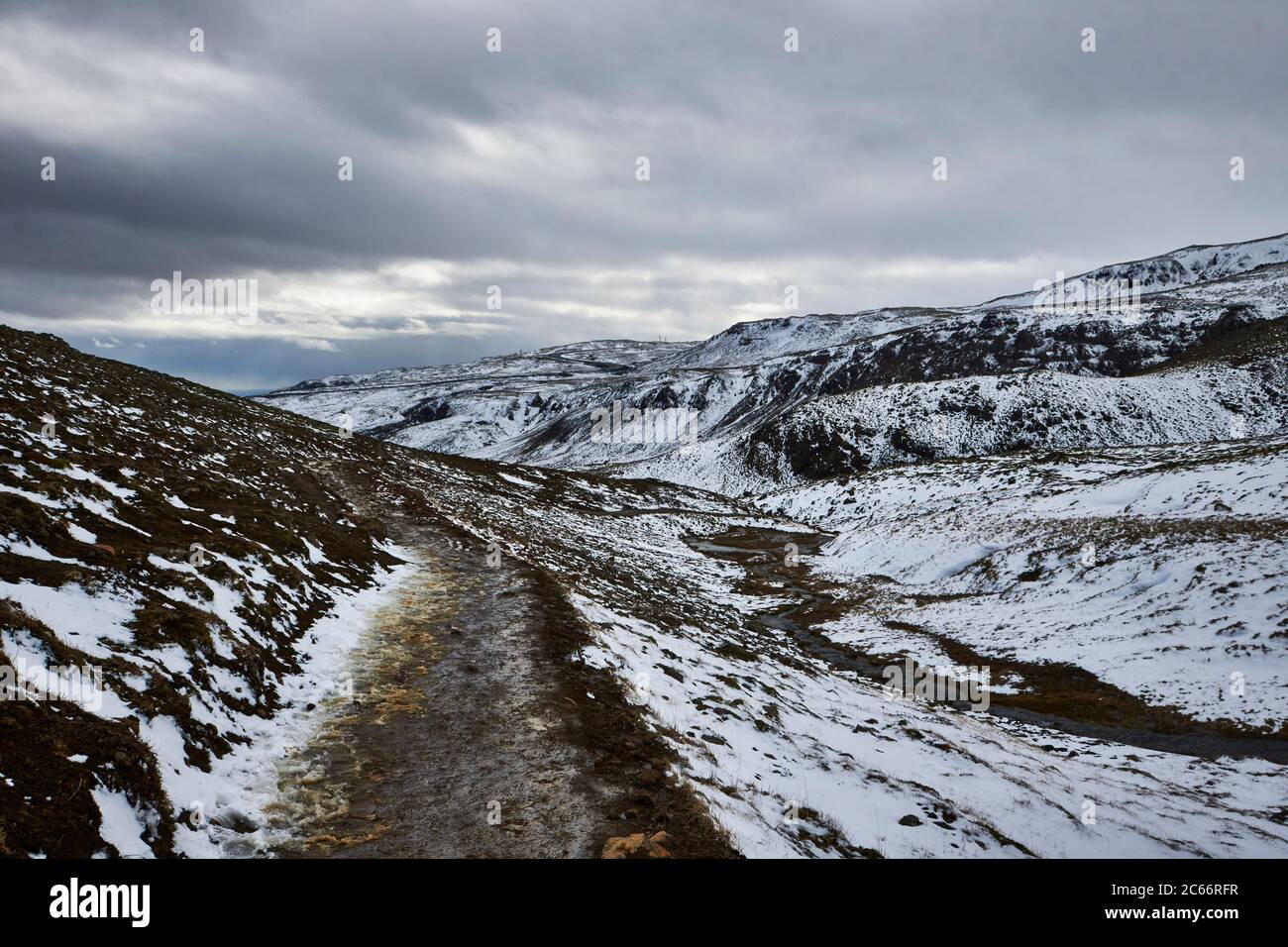 Islandia, el valle de Reykjadalur, Hveragerdi, montañas nevadas y fuentes geotérmicas Foto de stock