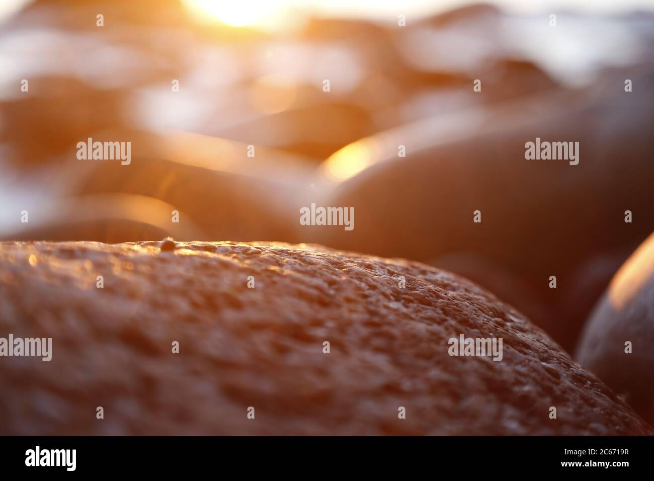 Piedras de playa y piedras de Stony puestas de sol en el cierre de la tarde, textura puesta de sol y amanecer Foto de stock