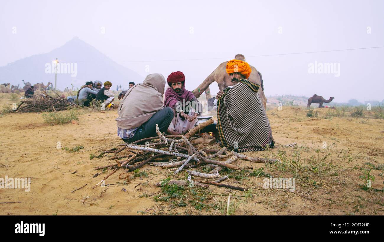 Nómadas sentados junto a un incendio en Pushkar, Rajasthan, India Foto de stock