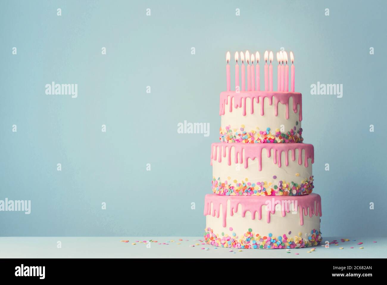 Pastel de cumpleaños escalonado con escarcha y doce velas Foto de stock