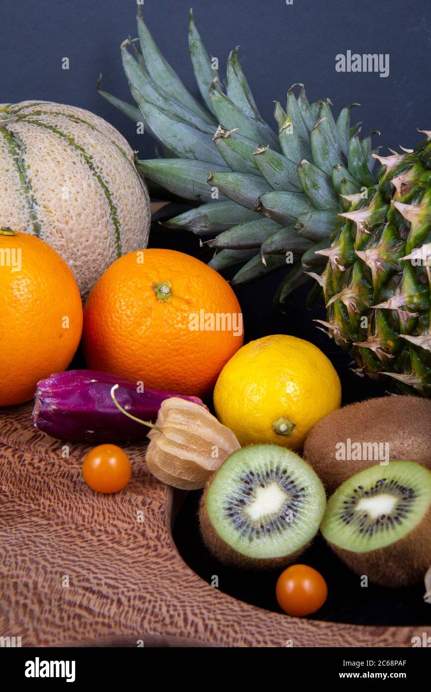 Una imagen de varias frutas. Melón de melón, piña, algunas kiwis, naranjas, limones, higo bárbaro y algunas frutas de farol chinas. Foto de stock
