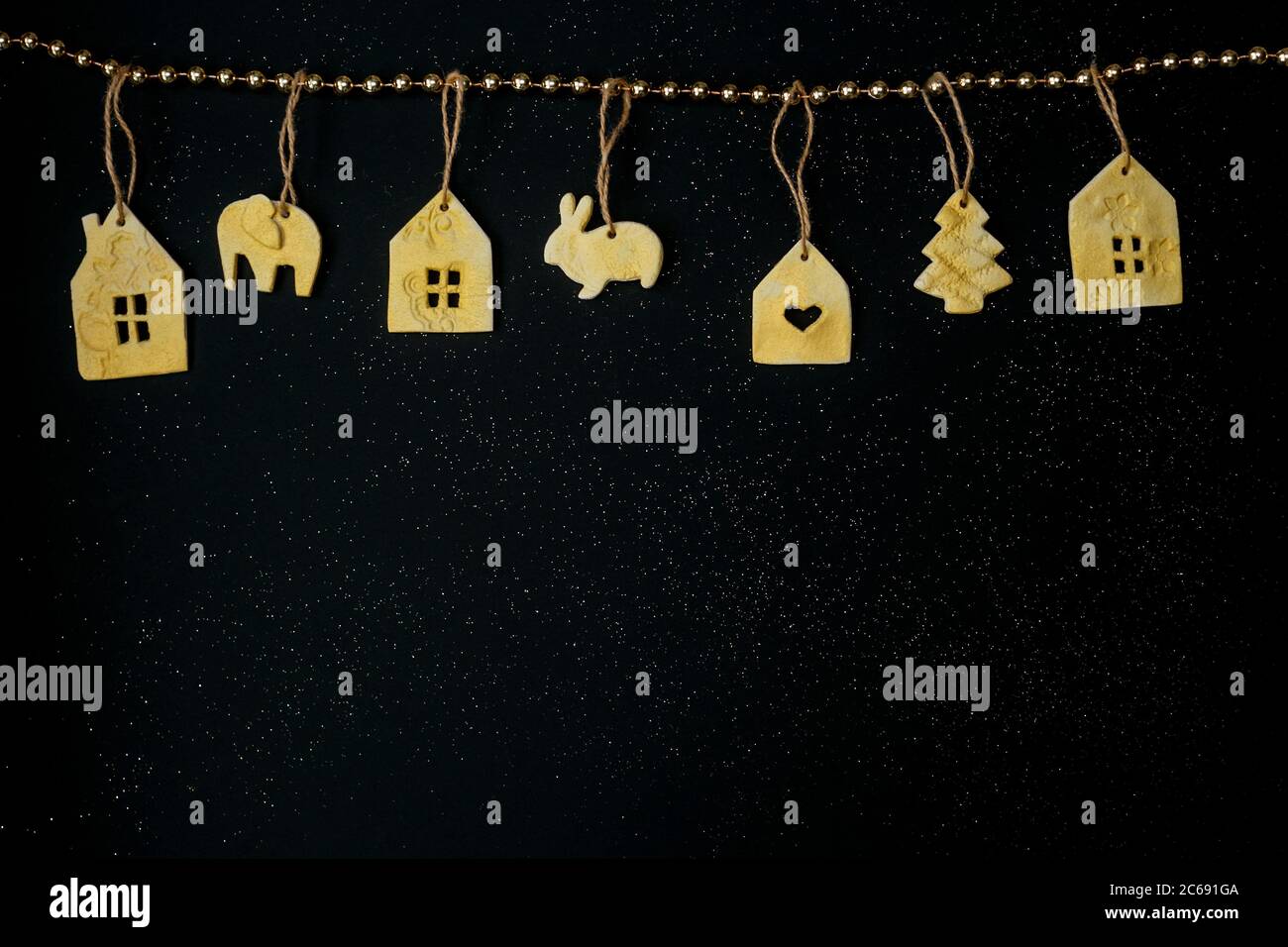 Hermosa decoración de Navidad con juguetes hechos a mano y nieve sobre fondo estrellas negras. Diseño plano. Espacio de copia. Horizontal. Foto de stock