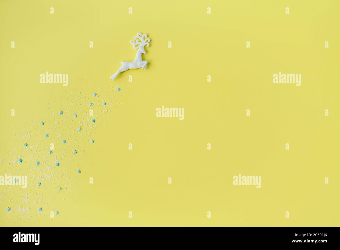 Hermoso ciervo de Navidad con estrellas sobre fondo amarillo. Diseño plano. Espacio de copia. Horizontal. Foto de stock