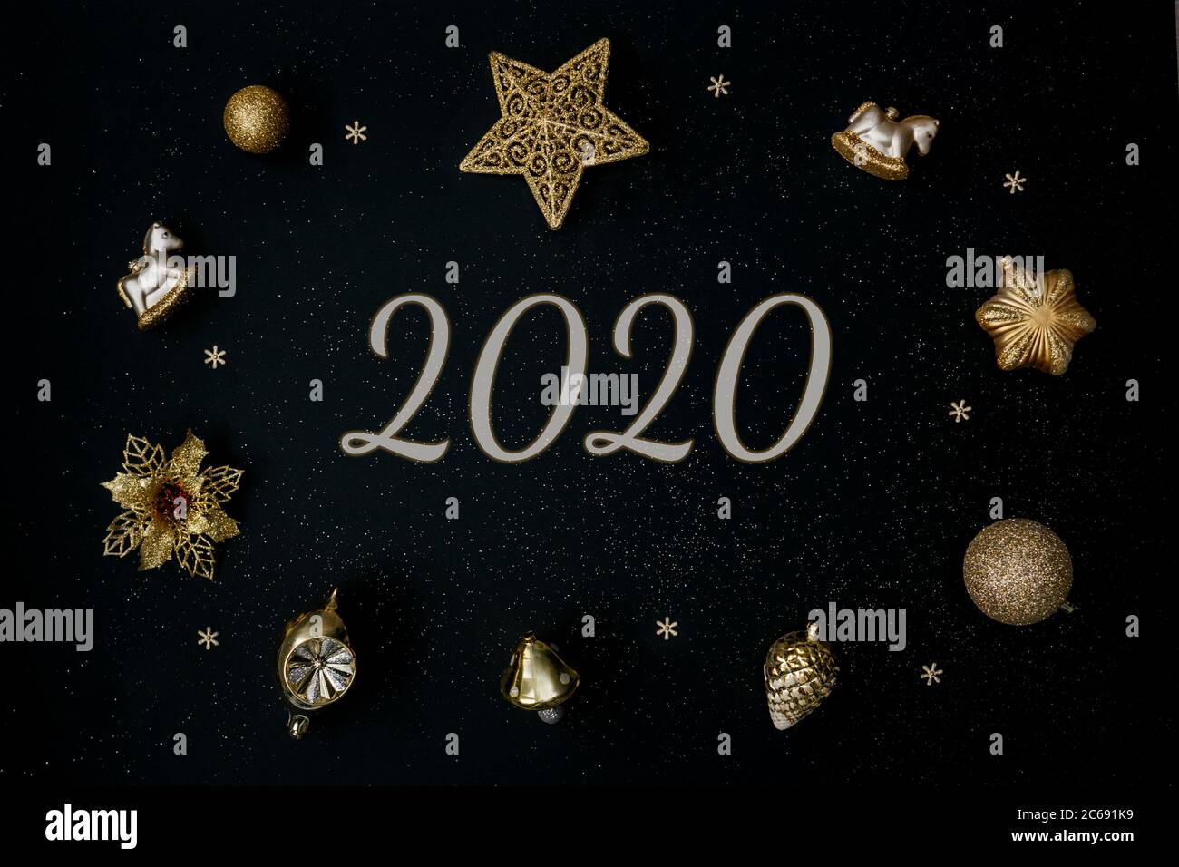 Hermosa decoración de Navidad dorada con bolas sobre fondo negro. Diseño plano. Espacio de copia. Horizontal. 2020 años Foto de stock