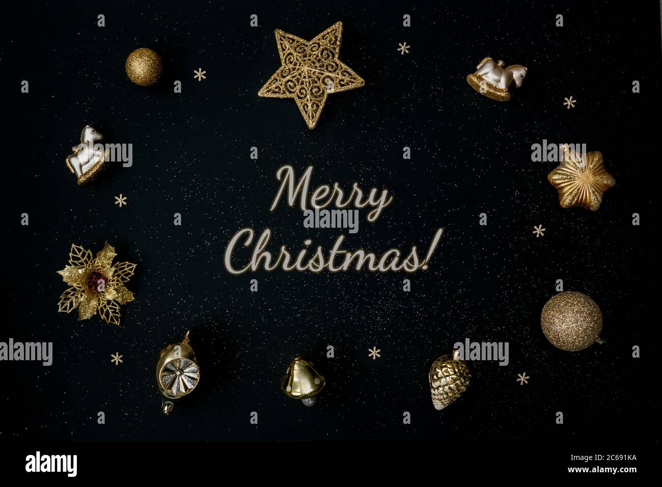Hermosa decoración de Navidad dorada con bolas sobre fondo negro. Diseño plano. Letras Feliz Navidad. Foto de stock
