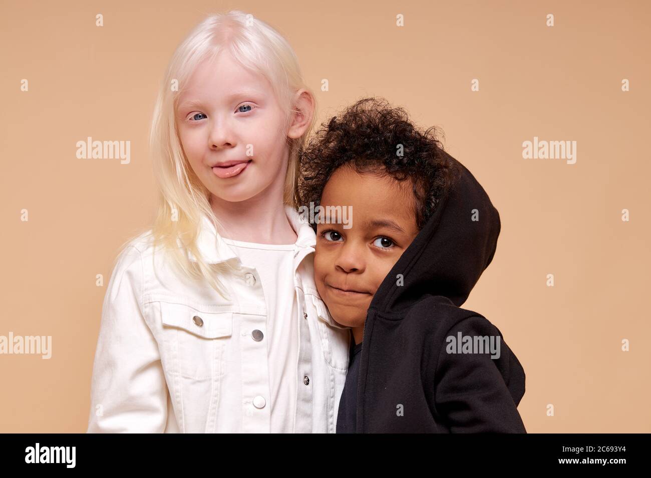 hermosa chica albina con pequeño afro multiracial niño aislado, chica  abraza a su amiga negra. chica mostrar lengua a cámara. inusual belleza  natural, albini Fotografía de stock - Alamy