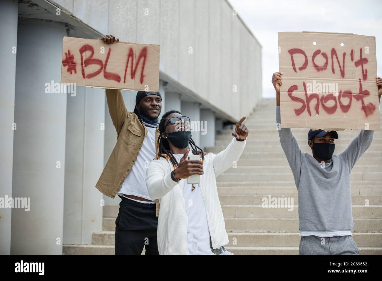 Las protestas de vidas negras importan a nivel mundial. Tres personas afroamericanas con carteles en la calle, personas negras insatisfechas con la injusticia policial y el movimiento Foto de stock