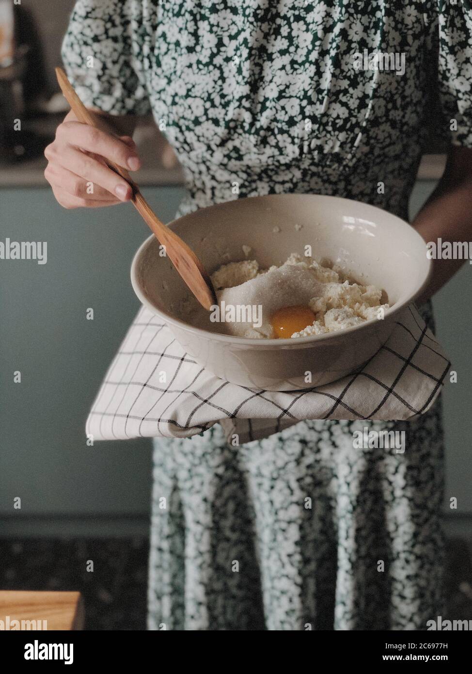 Mujer de pie en una cocina haciendo una tarta de queso Foto de stock