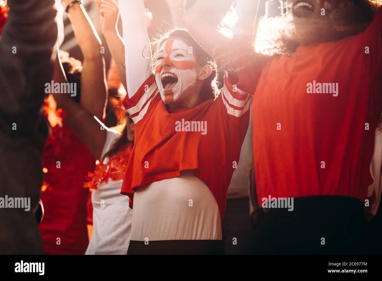 Entusiasmados aficionados al fútbol de Inglaterra celebrando en stands. Los seguidores del fútbol inglés animan a un gol en el estadio. Foto de stock