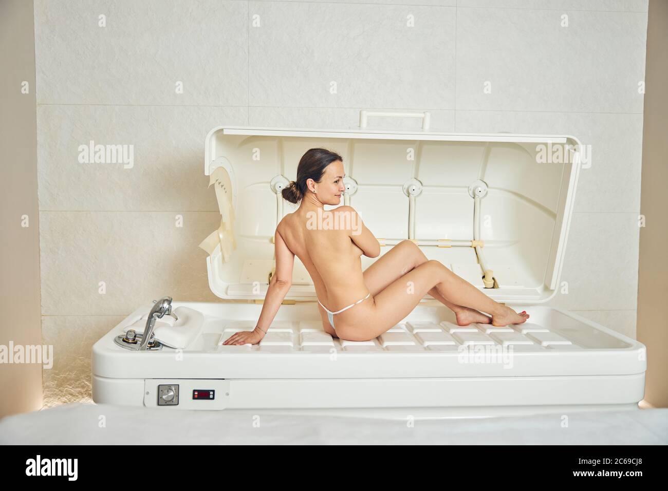 Mujer positiva que se ve relajado en cápsula de spa sin ropa Fotografía de  stock - Alamy