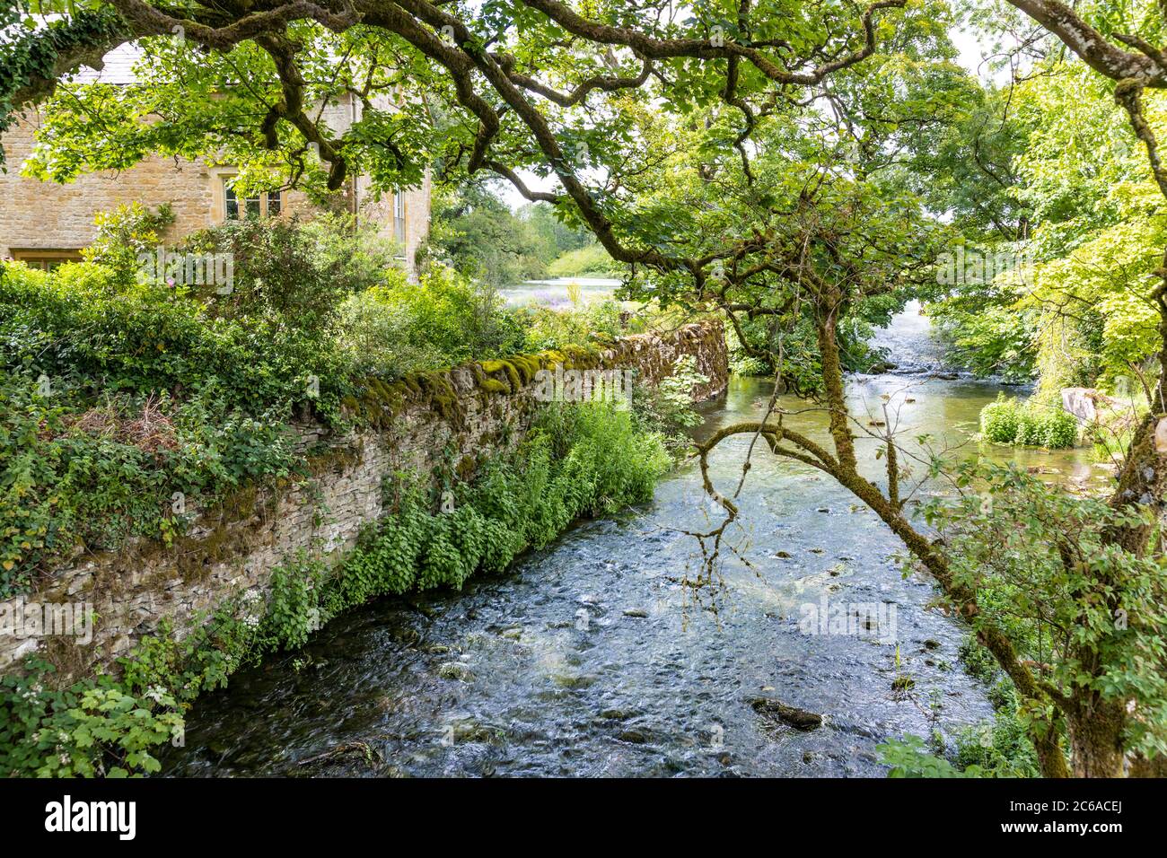 El río Dikler pasando por el antiguo molino en el pueblo de Cotswold de Upper Swell, Gloucestershire Reino Unido Foto de stock