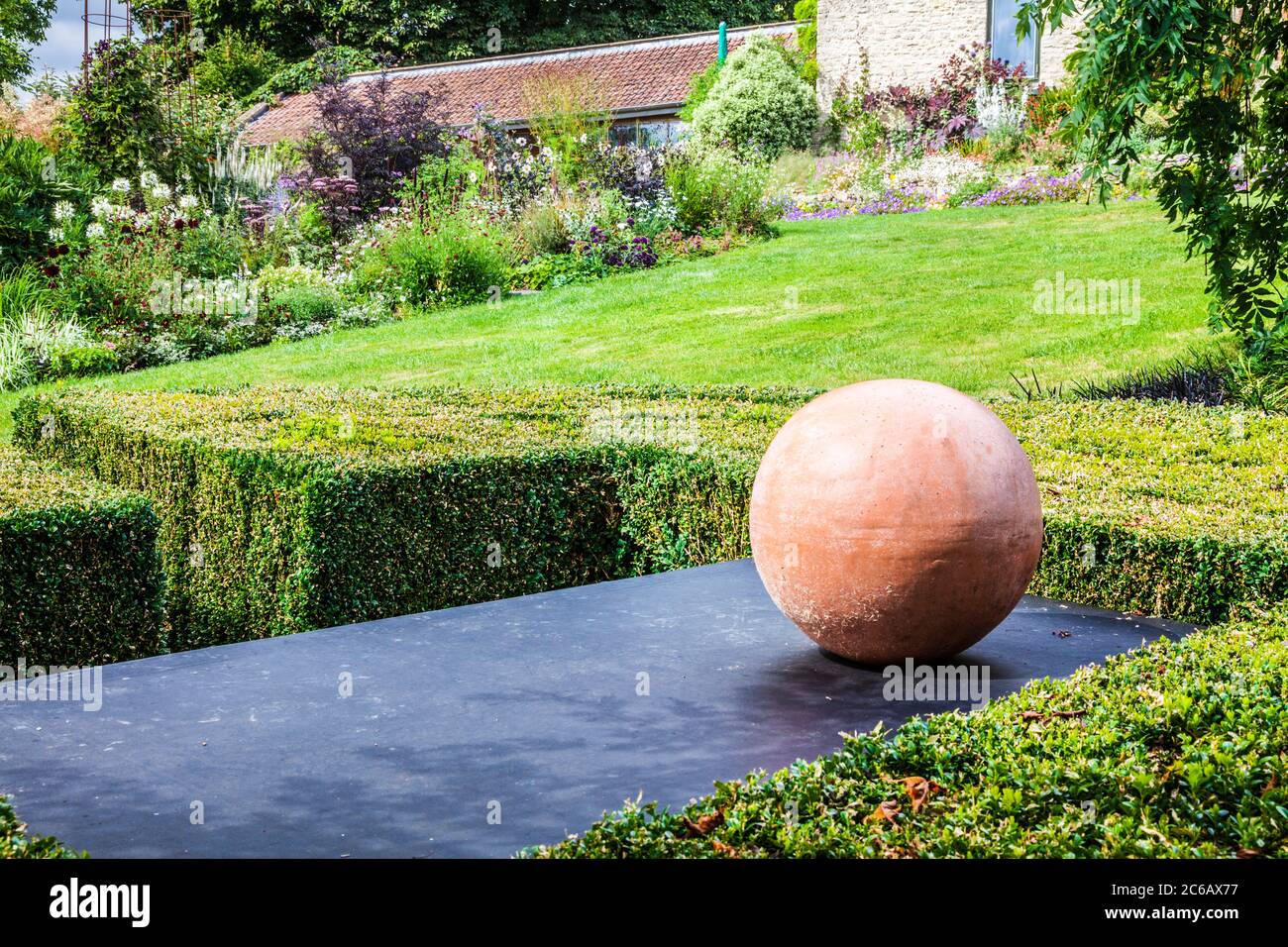 Un pedazo de arte moderno del jardín en un jardín inglés del campo. Foto de stock