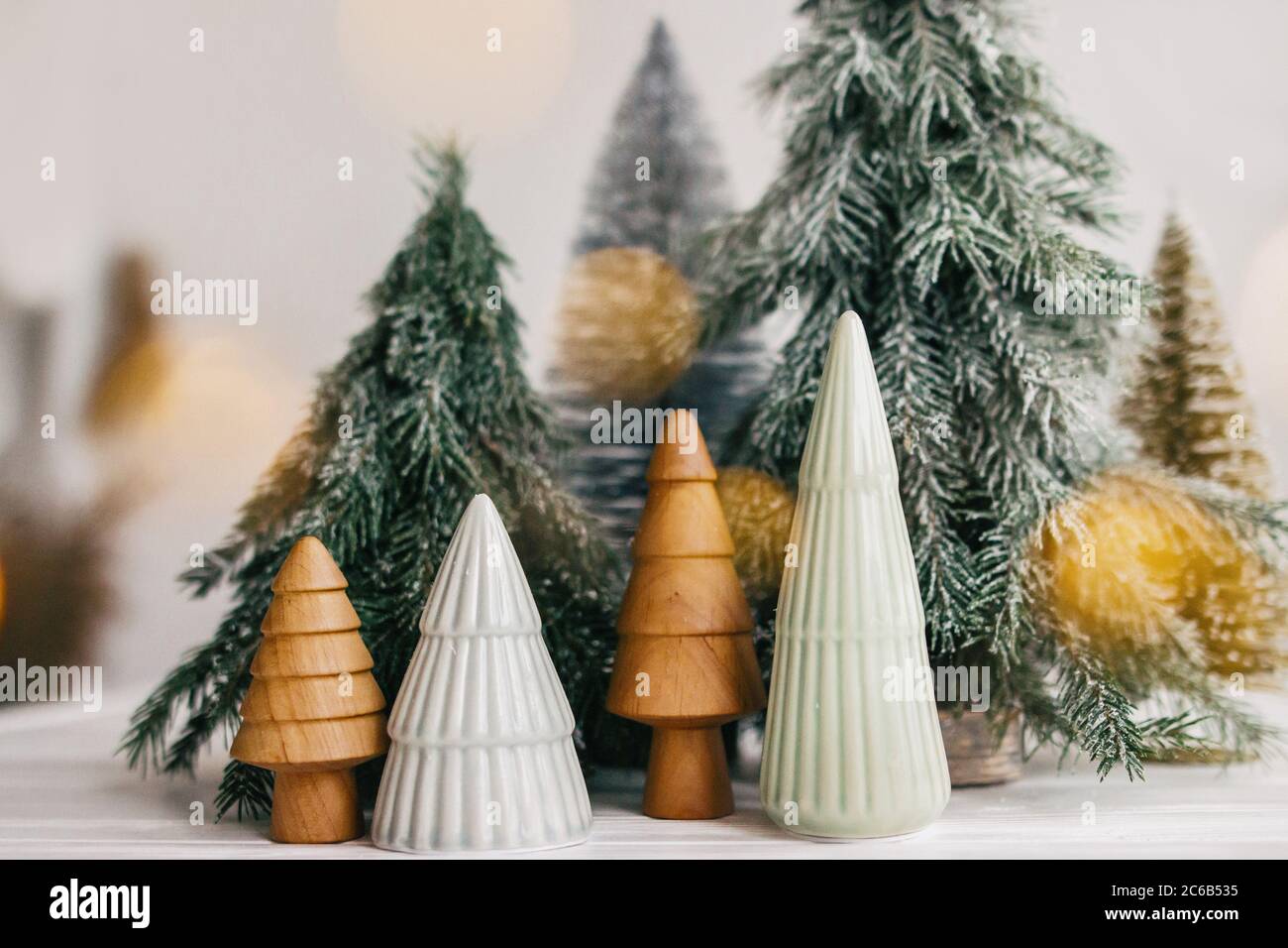Feliz Navidad. Los árboles de Navidad y las luces doradas se encenderán  sobre fondo blanco. Bosque mágico de invierno, decoración moderna festiva.  Cerámica en miniatura, woo Fotografía de stock - Alamy