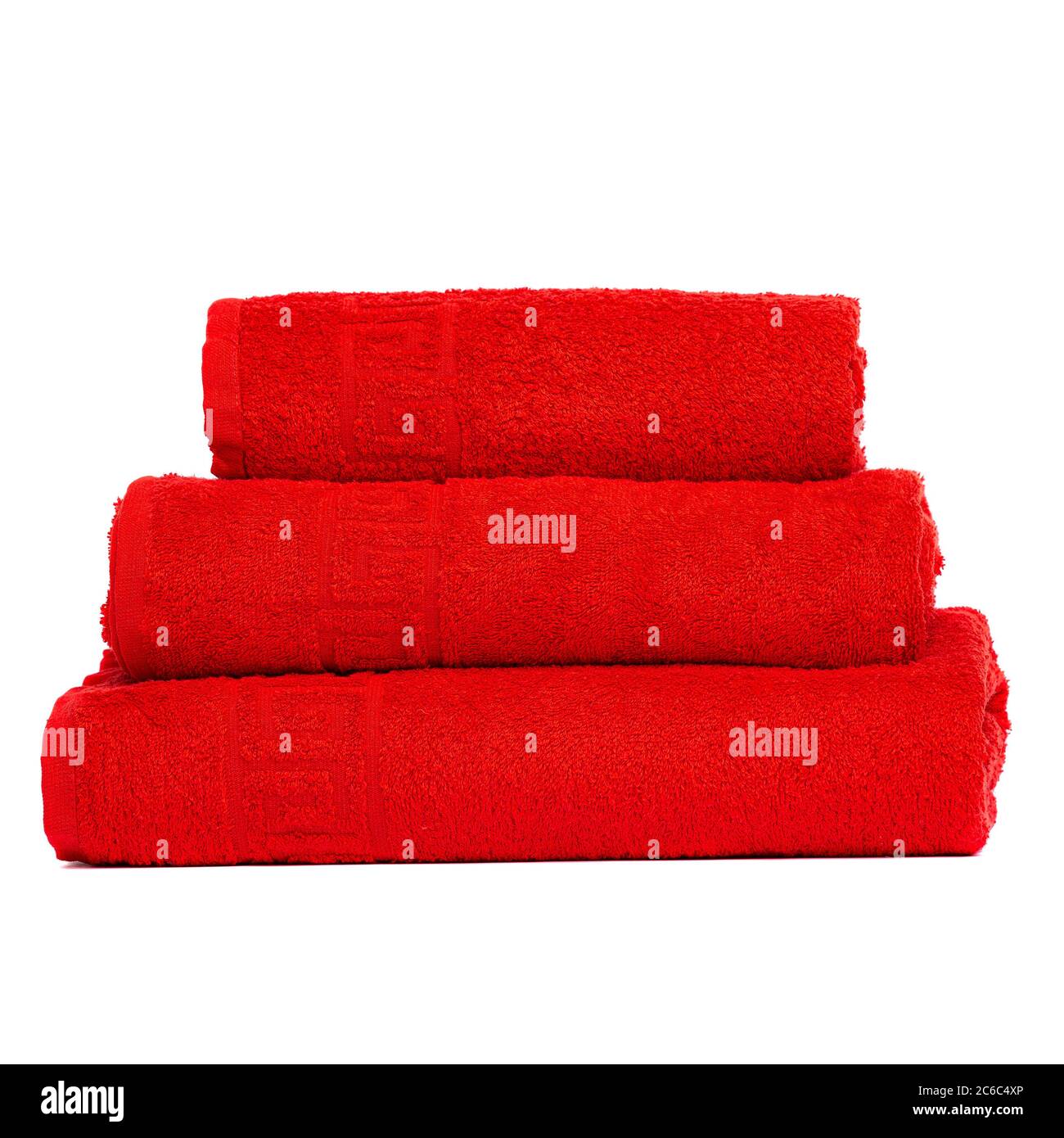 Tres toallas de frote de color rojo, toalla de dormitorio en fondo blanco.  Toallas de baño rojas de colores aisladas sobre blanco. Apile toallas rojas.  Pila de toallas de colores Fotografía de