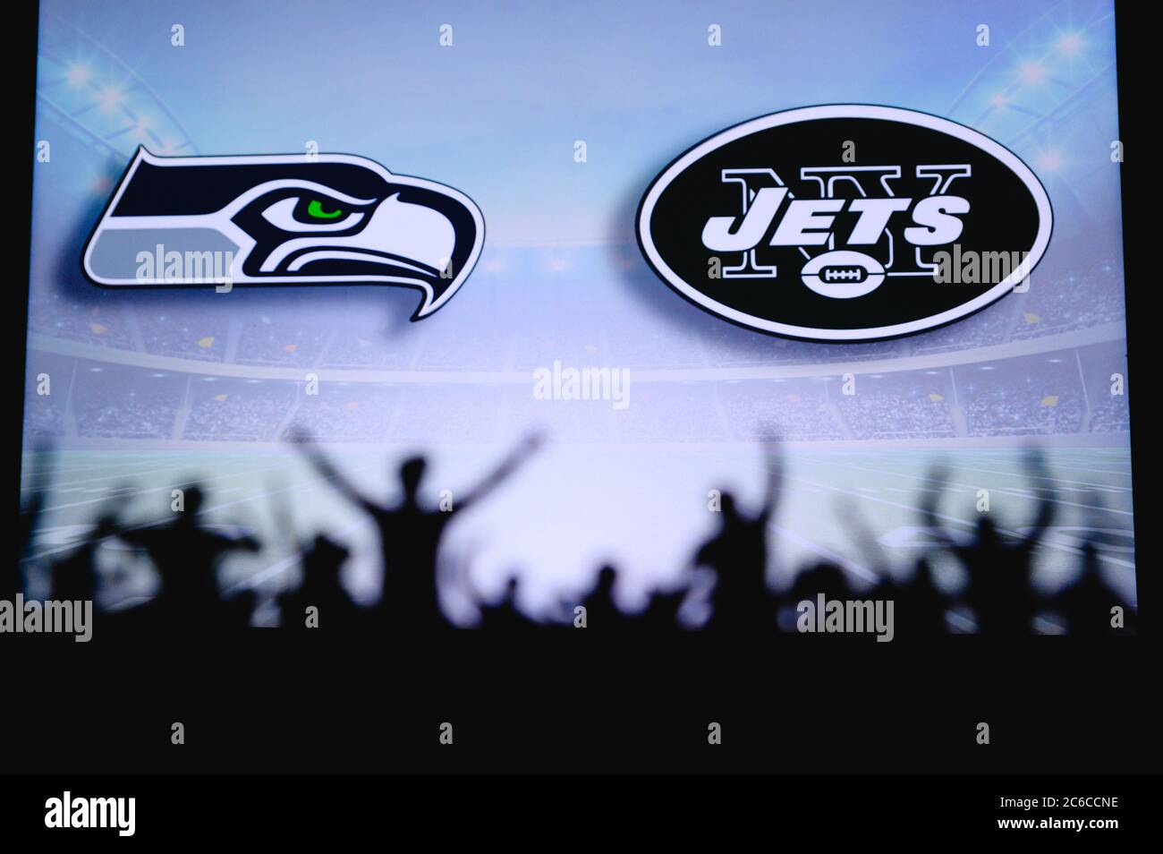 Seattle Seahawks vs. New York Jets. Apoyo de los fans en el NFL Game. Silueta de los seguidores, gran pantalla con dos rivales en el fondo. Foto de stock