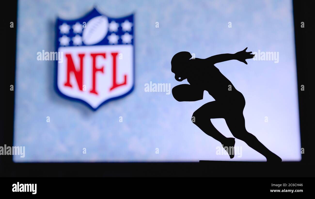 La Liga Nacional de Fútbol – NFL. Silueta de futbolista profesional estadounidense. Logo del club de la NFL en el fondo, editar espacio. Foto de stock