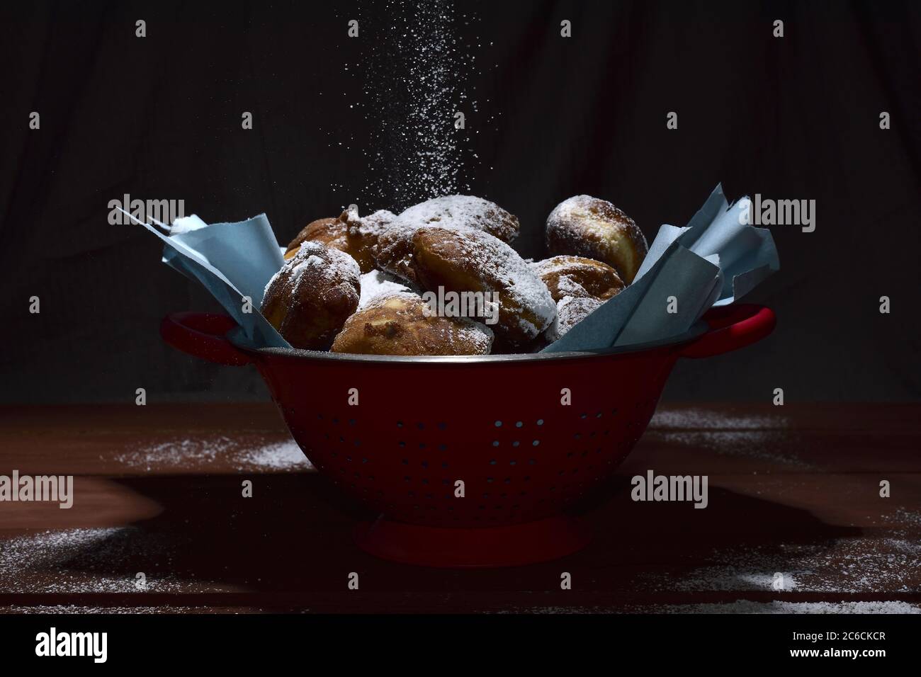 fritters dulces en colador bañado en azúcar en polvo Foto de stock