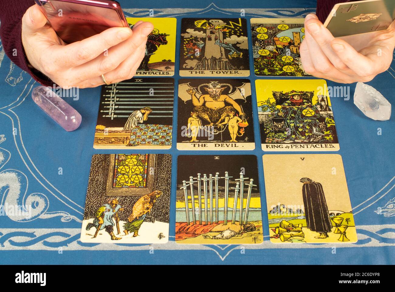 Tarot lectura con ayuda de teléfono móvil rosa. Cartas dispuestas en  cuadrícula de nueve con cristales de fondo Fotografía de stock - Alamy