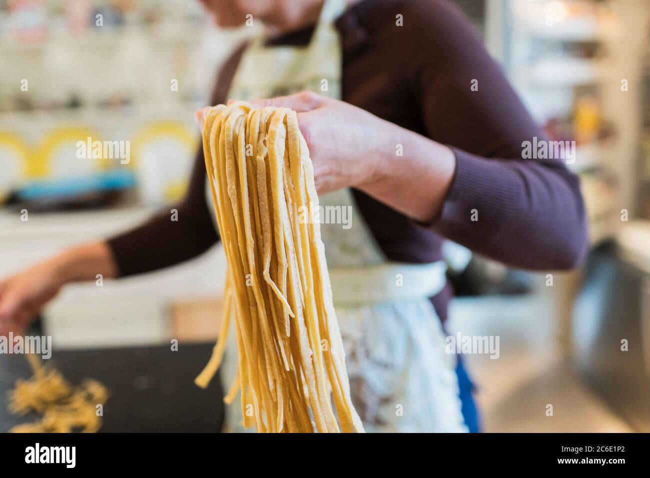 Mujer haciendo pasta casera fresca en la cocina Foto de stock