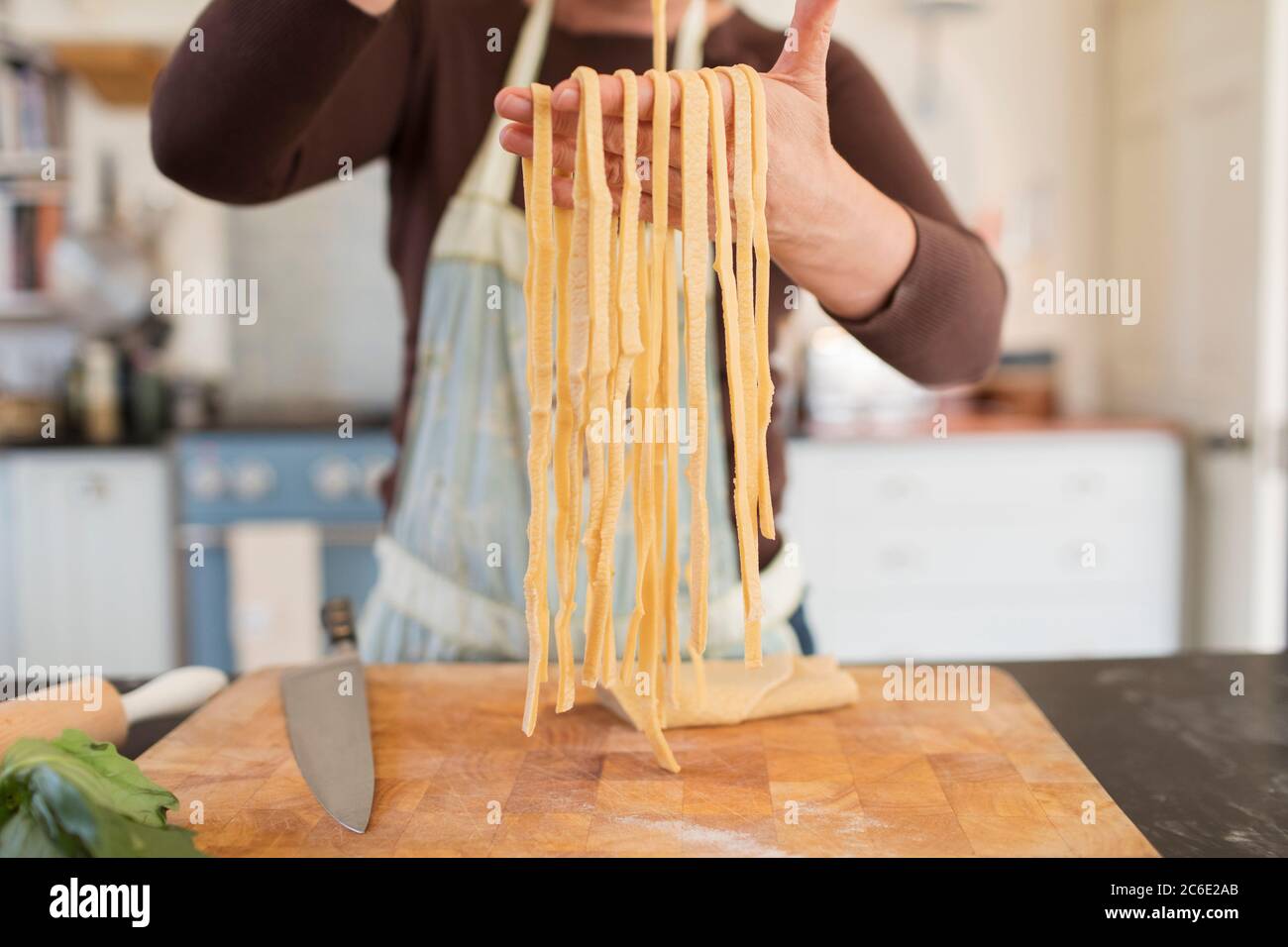 Mujer cercana haciendo pasta casera fresca en la cocina Foto de stock