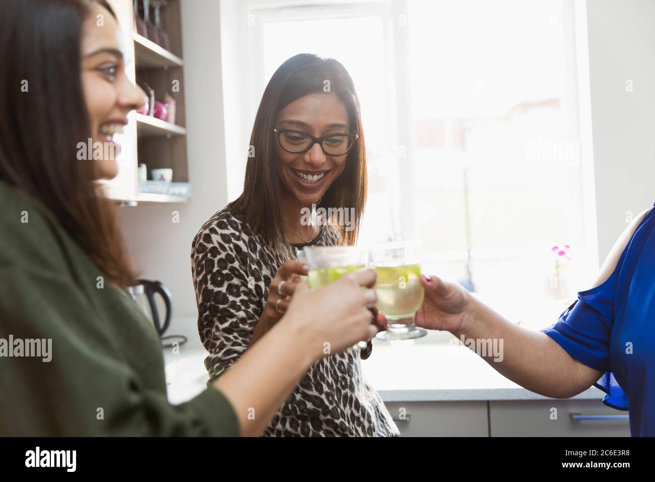 Mujeres felices bebiendo en la cocina Foto de stock
