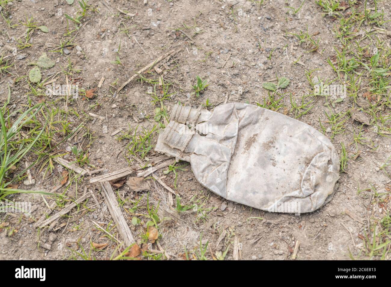 Vaciar la botella de refrescos en un lado de una tranquila carretera rural. Ejemplo de contaminación plástica en el campo del Reino Unido, basura plástica de un solo uso, basura plástica Foto de stock