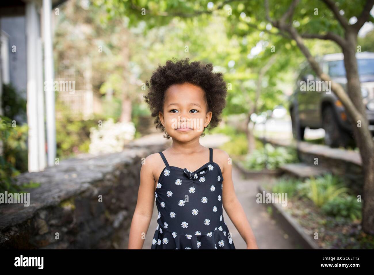 Retrato de una joven hermosa niña afroamericana de pie con confianza en el medio ambiente urbano. Foto de stock