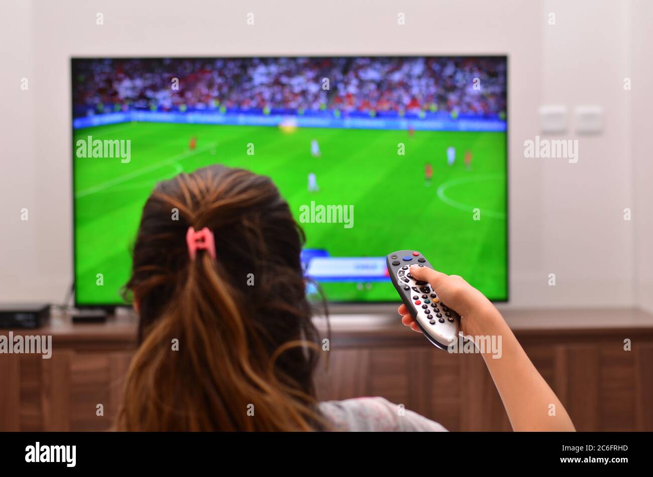 Mujeres viendo un partido de fútbol en la televisión y utilizar el mando a  distancia Fotografía de stock - Alamy