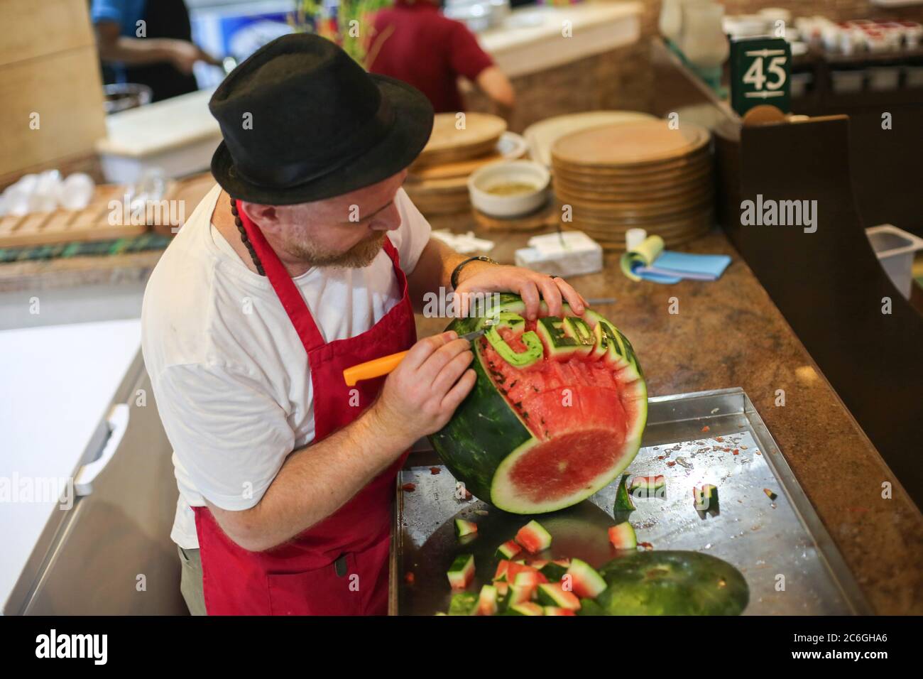 Gaza. 9 de julio de 2020. Chef Wareef Qassem, de 40 años, hace las palabras sobre sandías como una manera de atraer clientes en la ciudad de Gaza, el 9 de julio de 2020. Crédito: Rizek Abdeljawad/Xinhua/Alamy Live News Foto de stock