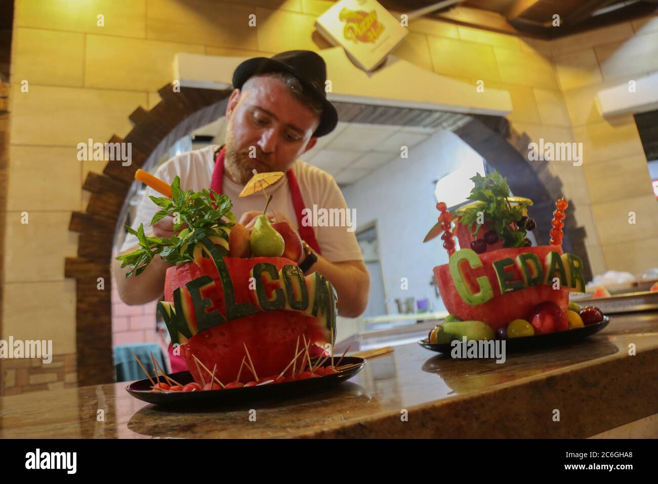 Gaza. 9 de julio de 2020. Chef Wareef Qassem, de 40 años, hace las palabras sobre sandías como una manera de atraer clientes en la ciudad de Gaza, el 9 de julio de 2020. Crédito: Rizek Abdeljawad/Xinhua/Alamy Live News Foto de stock