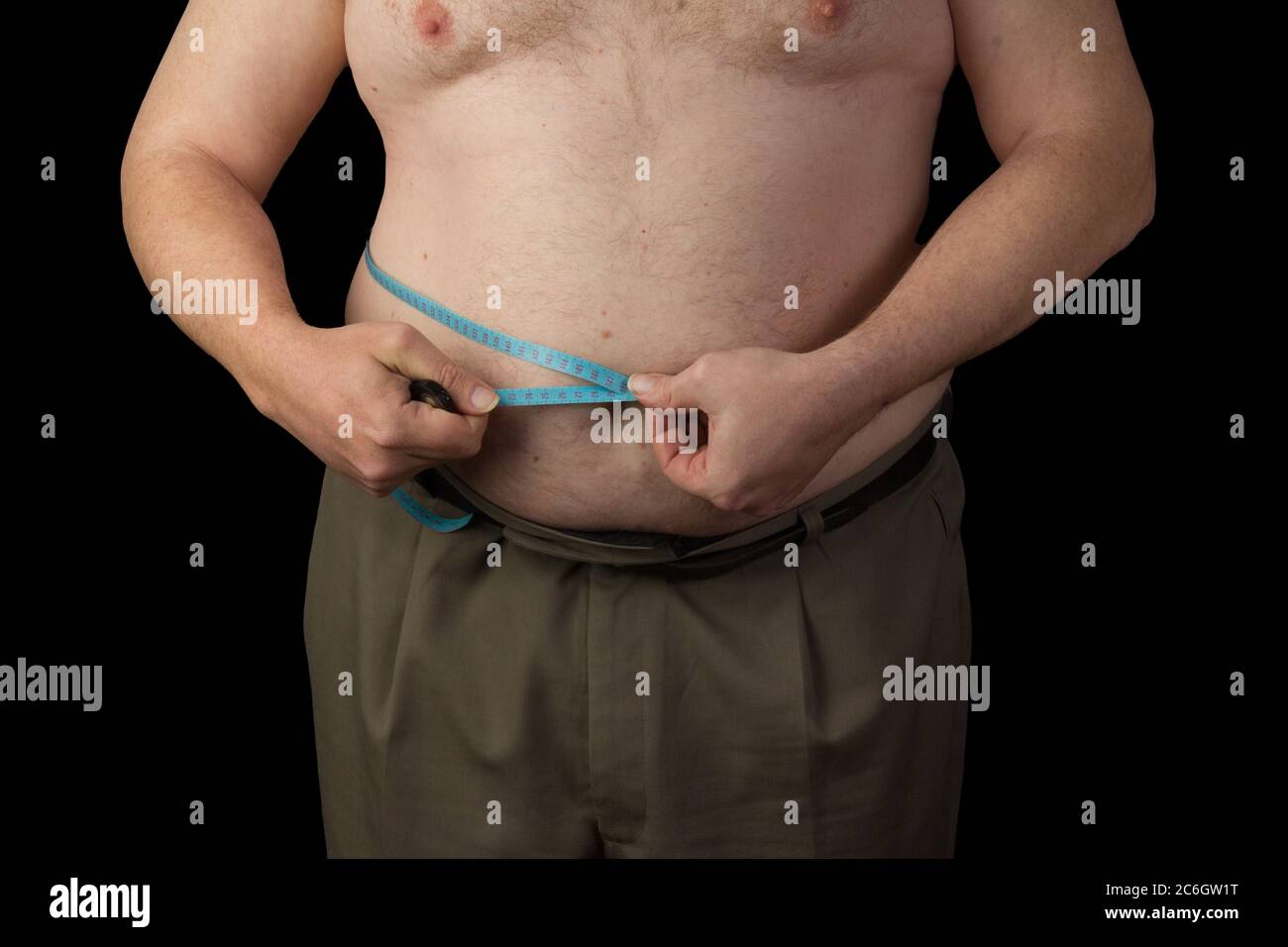 Hombre gordo sosteniendo una cinta métrica, mida su abdomen. Pérdida de peso. Foto sobre fondo negro aislado Foto de stock